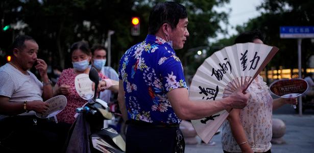23.jul.22 - Pessoas usam ventiladores enquanto se reúnem em um parque em meio a um alerta de onda de calor em Xangai, China