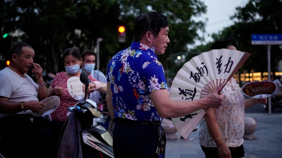 23.jul.22 - Pessoas usam ventiladores enquanto se reúnem em um parque em meio a um alerta de onda de calor em Xangai, China - ALY SONG/REUTERS