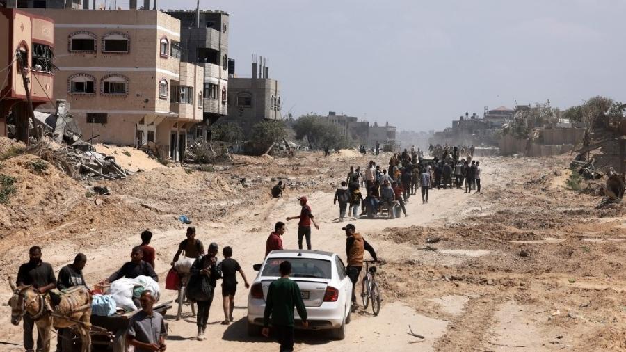 Os palestinos que se refugiaram em Rafah deixaram a cidade para regressar a Khan Yunis depois de Israel ter retirado as suas forças terrestres do sul da Faixa de Gaza, em 7 de abril de 2024 - MOHAMMED ABED/AFP