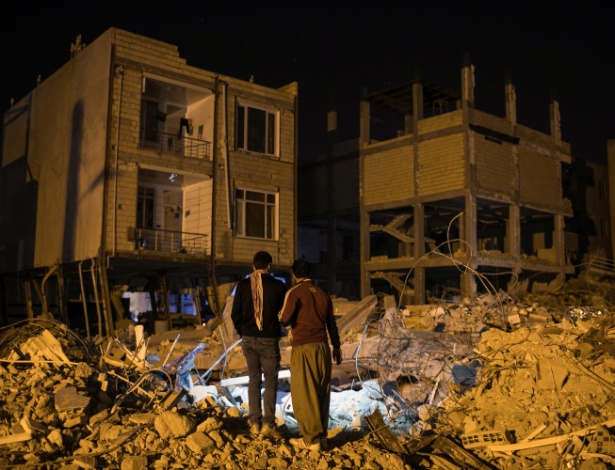 14.nov.2017 - Homens procuram objetos que ainda possam ser utilizados em meio a destroços de prédio que desabou em terremoto, em Sarpol-e Zahab, Irã - Arash Khamooshi/The New York Times