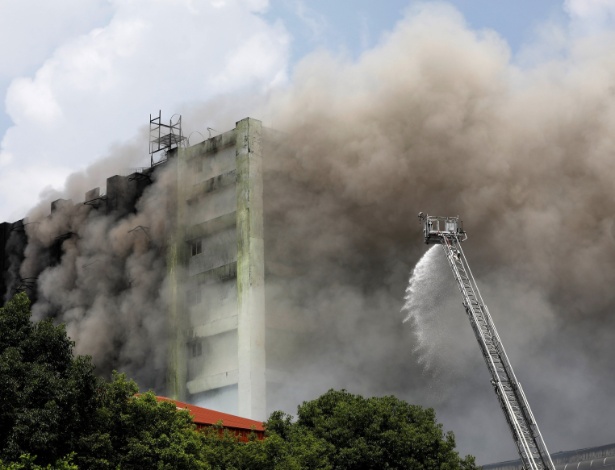 Bombeiros trabalham na contenção de incêndio em fábrica de produtos eletrônicos - Tyrone Siu/Reuters