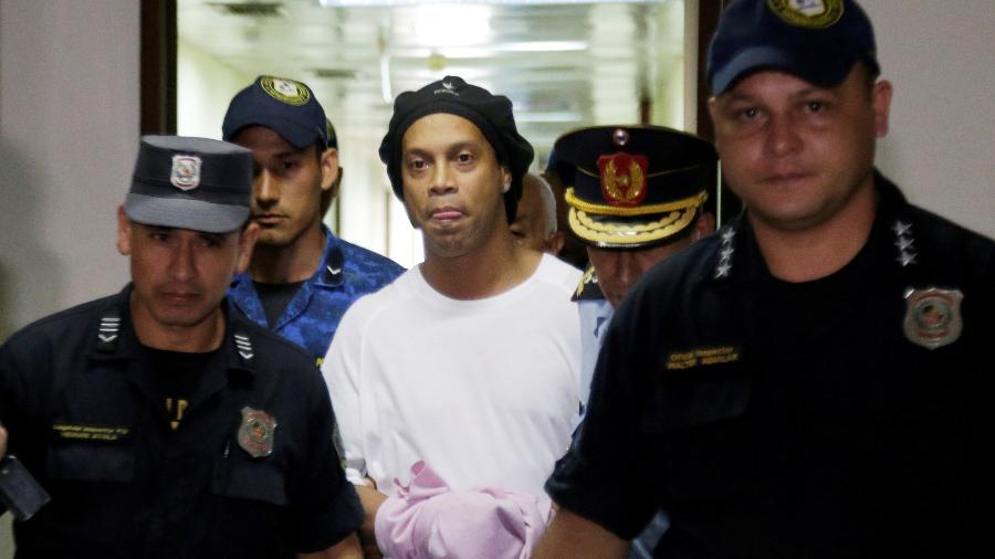 Ronaldinho é escoltado pela polícia em tribunal do Paraguai - JORGE ADORNO