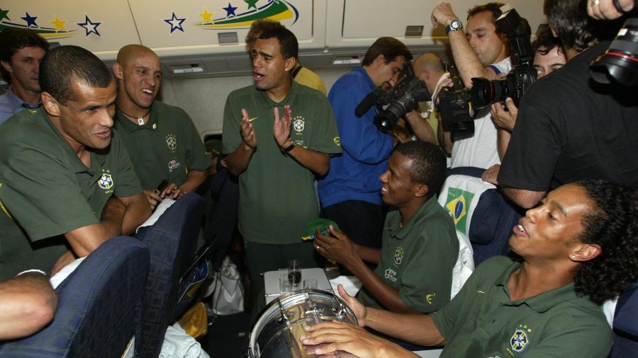 Rivaldo, Roberto Carlos, Denílson, Roque Júnior e Ronaldinho Gaúcho fazem roda de samba no avião na volta para o Brasil após a conquista do penta na Copa do Japão e Coreia, em 2002 - Paulo Whitaker / Reuters