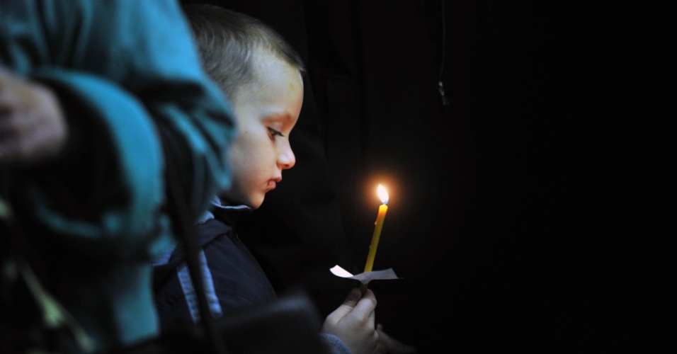5.nov.2015 - Menino reza durante velório de vítima do acidente com avião russo, em igreja de Veliky Novgorod, na Rússia