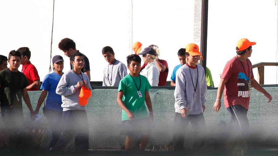 28.jun.2019 - Crianças imigrantes que foram separadas de suas famílias caminham em um centre de detenção em Homestead, na Flórida - Rhona Wise/AFP