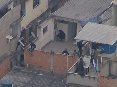 Homens pulam entre casas durante operação no Jacarezinho, no Rio de Janeiro - Reprodução/Rede Globo