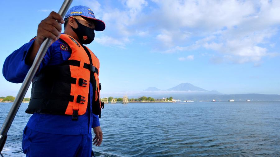30.jun.2021 - Homem busca por sobreviventes no mar após uma balsa de passageiros afundar na costa da ilha de Bali - Dimas Dhani/AFP