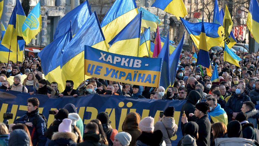 Manifestantes carregam uma faixa com os dizeres "Kharkiv é Ucrânia" durante uma Marcha da Unidade em meio a crescentes tensões com a Rússia, em Kharkiv, leste da Ucrânia, em 5 de fevereiro de 2022. - SERGEY BOBOK/AFP