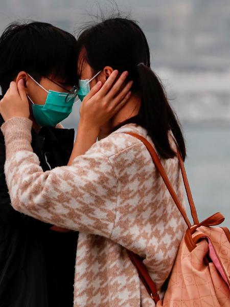 Casal se abraça usando máscaras - Tyrone Siu/Reuters