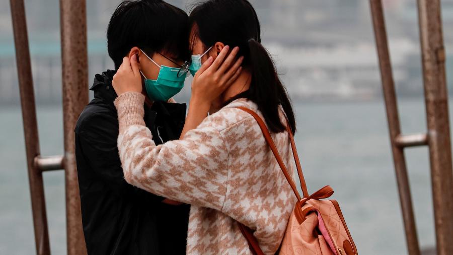 14.fev.2020 - Casal se abraça usando máscaras no Dia de São Valentim, na China - Tyrone Siu/Reuters