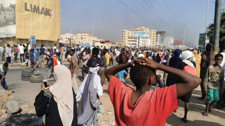 Manifestantes sudaneses queimam pneus para bloquear uma estrada na capital Cartum, para denunciar detenções noturnas pelo exército de membros do governo sudanês - AFP
