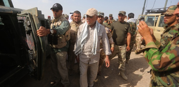 Comandante da milícia xiita Hadi al-Ameri caminha entre forças de segurança iraquianas - Ahmad al-Rubaye/AFP