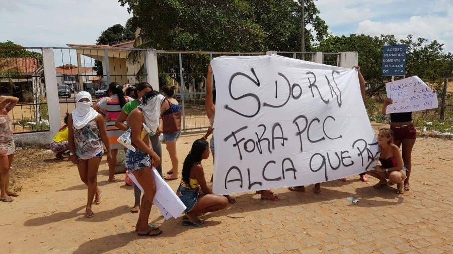 20.jan.2017 - Na porta de Alcaçuz, um pequeno grupo de mulheres mostra uma faixa e cartazes pedindo a saída de integrantes do PCC (Primeiro Comando da Capital) da unidade - Beto Macário/UOL