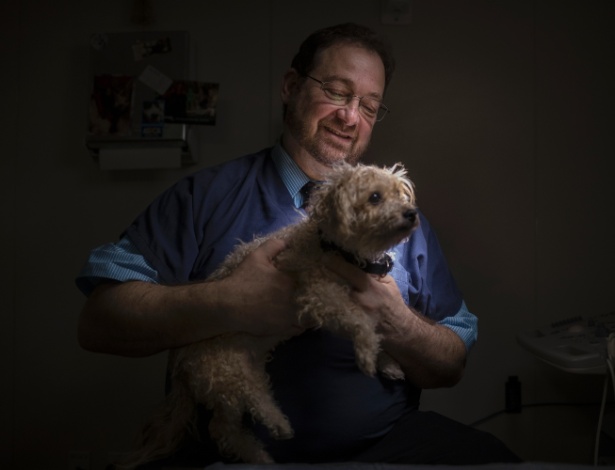 O perito veterinário Robert Reisman com Charlotte, a mestiça de poodle com maltês de 2 anos de idade encontrada em uma lata de lixo, em Nova York - Victor J. Blue/The New York Times