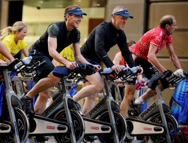 Australianos fazem exercícios em bicicletas no meio de Sydney, na Austrália - Greg WOOD/AFP