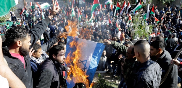 8.dez.2017 - Manifestantes queimam bandeira de Israel durante protesto contra decisão do presidente dos EUA Donald Trump reconhecer Jerusalém como capital israelense, em Damasco, Síria - Louai Beshara/ AFP