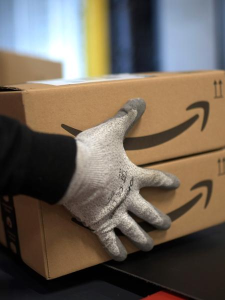 Entregador prepara pacotes com produtos da Amazon no centro de distribuição - Ina Fassbender/AFP
