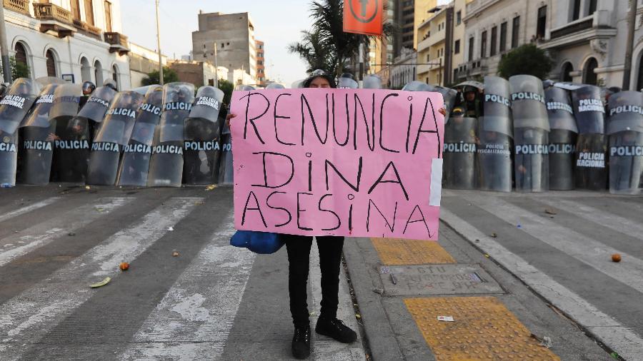 Manifestante segura cartaz que pede a renúncia da presidente Dina Boluarte e a chama de assassina - Lucas Aguayo/AFP