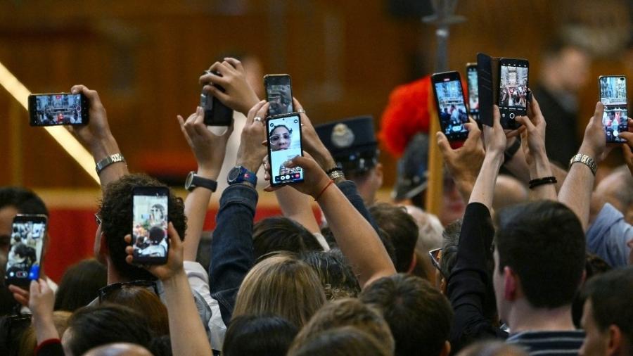 23.abr.2025 - Pessoas usam seus smartphones para gravar imagens multimídia perto do caixão enquanto o corpo do Papa Francisco é velado dentro da Basílica de São Pedro, no Vaticano 23.abr.2025 - Pessoas usam seus smartphones para gravar imagens multimídia perto do caixão enquanto o corpo do Papa Francisco é velado dentro da Basílica de São Pedro, no Vaticano