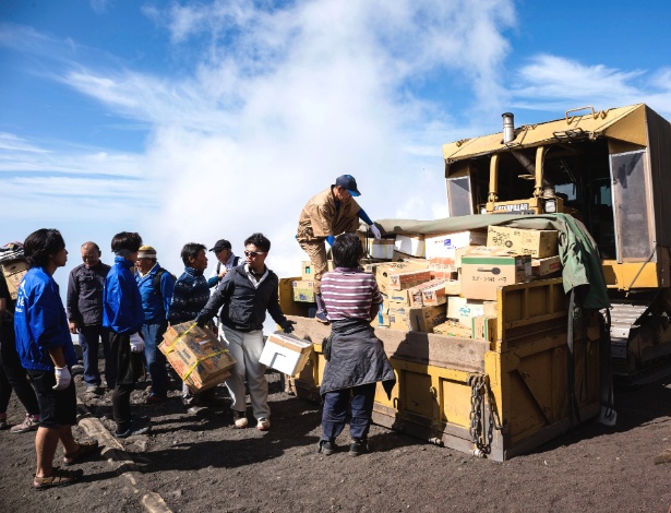 Trabalhadores descarregam trator que transporta suprimentos e correspondências do Monte Fuji, no Japão - Ko Sasaki/The New York Times
