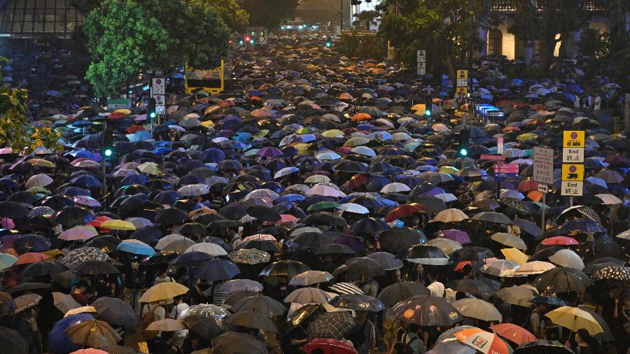 Manifestantes participam de protestos em Hong Kong segurando guarda-chuvas que, durante confrontos com a polícia, foram utilizados como escudos contra gás - Anthony Wallace/AFP