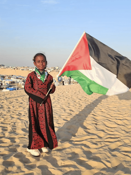 Lama Jamous segura uma bandeira da Palestina em um campo de refugiados em Rafah