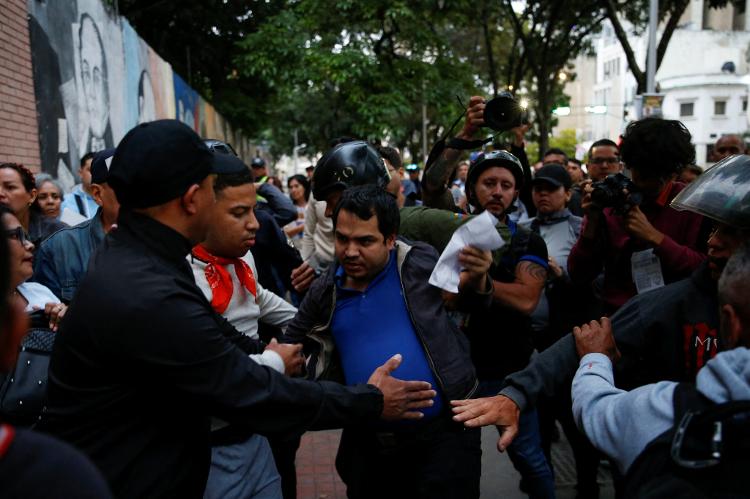 Voluntários do partido governista impedem voluntário da oposição de entrar na centro eleitoral de Andres Bello, em Caracas