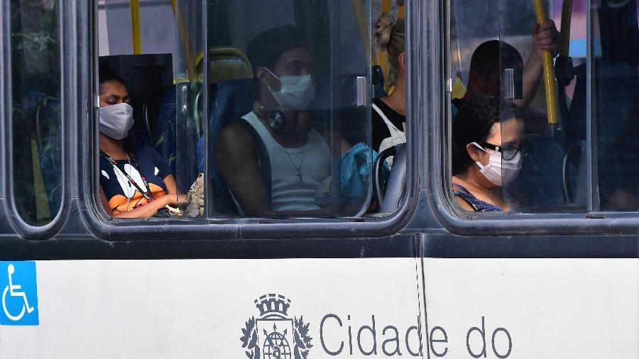 Pessoas usam máscaras em ônibus no bairro de Copacabana, na zona sul do Rio de Janeiro - PETER ILICCIEV/ESTADÃO CONTEÚDO