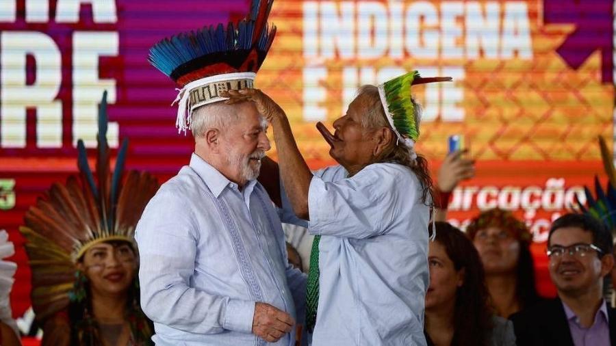 28.abr.2023 - Cacique Raoni coloca cocar na cabeça de Lula no Acampamento Terra Livre, em Brasília, quando o presidente anunciou as primeiras demarcações de terras indígenas