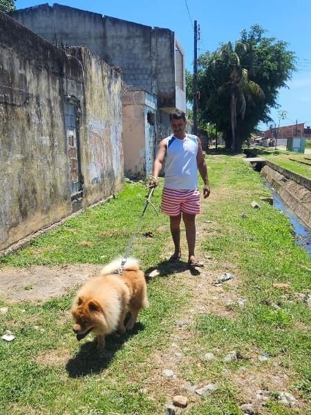 Osmar passeia com o cachorro em área próxima a mina que corre risco de desabar em Maceió