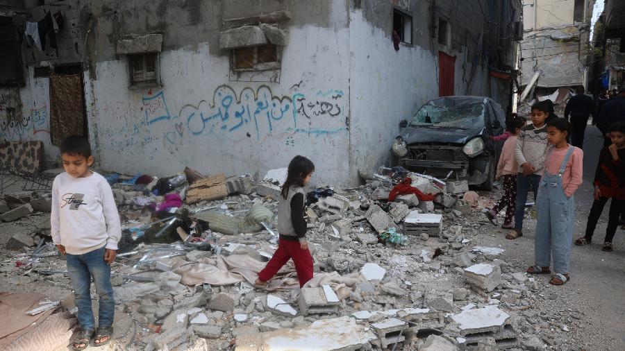 26.mar.2025 - Crianças palestinas sobre escombros após um ataque israelense anterior atingir um apartamento, matando Amir Hussein e seu filho Walid (não retratado), no campo de refugiados de Bureij, no centro da Faixa de Gaza 26.mar.2025 - Crianças palestinas sobre escombros após um ataque israelense anterior atingir um apartamento, matando Amir Hussein e seu filho Walid (não retratado), no campo de refugiados de Bureij, no centro da Faixa de Gaza