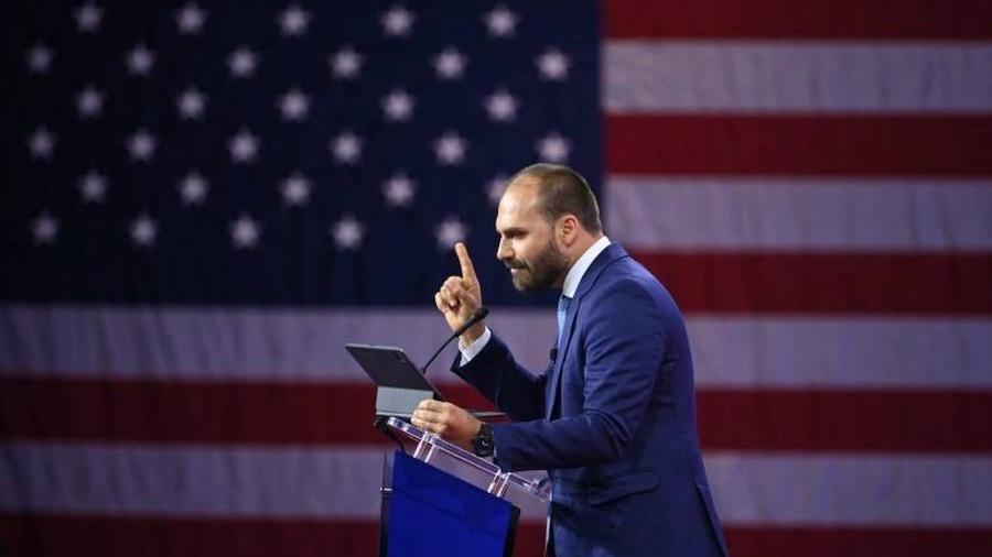 Deputado federal Eduardo Bolsonaro discursa em frente à bandeira dos Estados Unidos Deputado federal Eduardo Bolsonaro discursa em frente à bandeira dos Estados Unidos