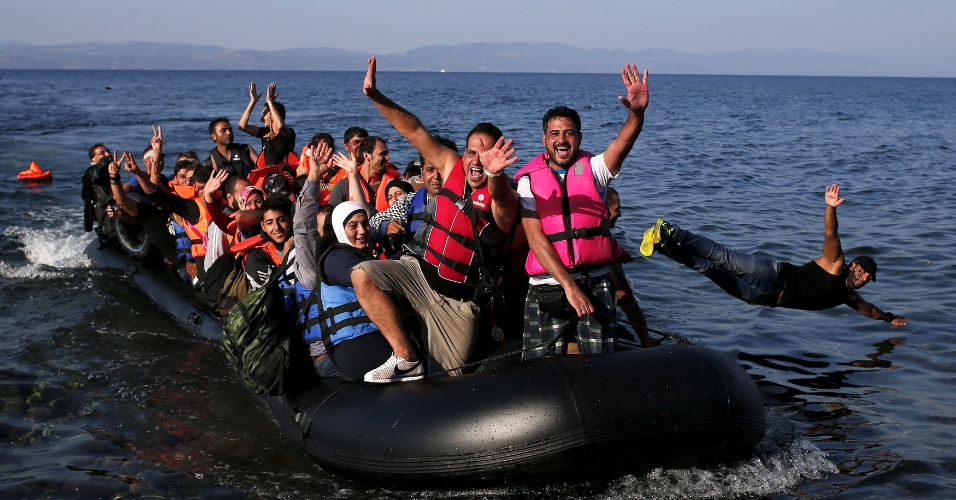 15.set.2015 - Refugiados sírios comemoram a chegada na ilha de Lesbos, na Grécia. A OIM (Organização Internacional para Migrações) alertou que o número de mortos de migrantes chegou a  3.800, sendo que 2.812 mortes foram registradas no mar Mediterrâneo