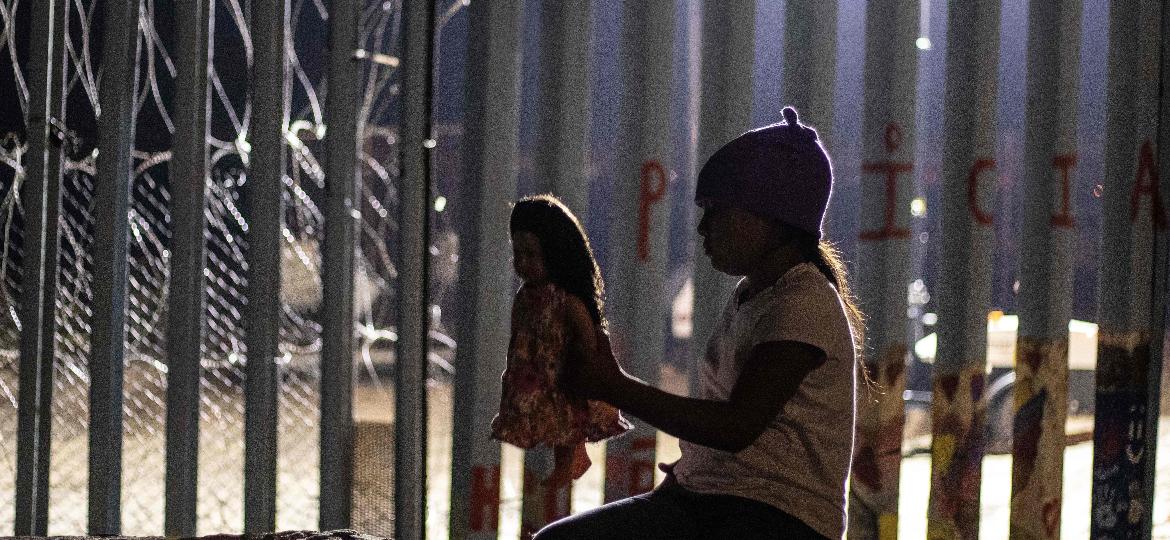 9.dez.2018 - Garota da Guatemala próxima junto à cerca da fronteira entre EUA e México, na cidade de Tijuana - Guillermo Arias / AFP