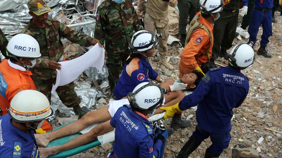 Sobrevivente é retirado com vida dos escombros do prédio que desabou em Sihanoukville, no Camboja, dois dias após a tragédia - Sub Rethy/AFP
