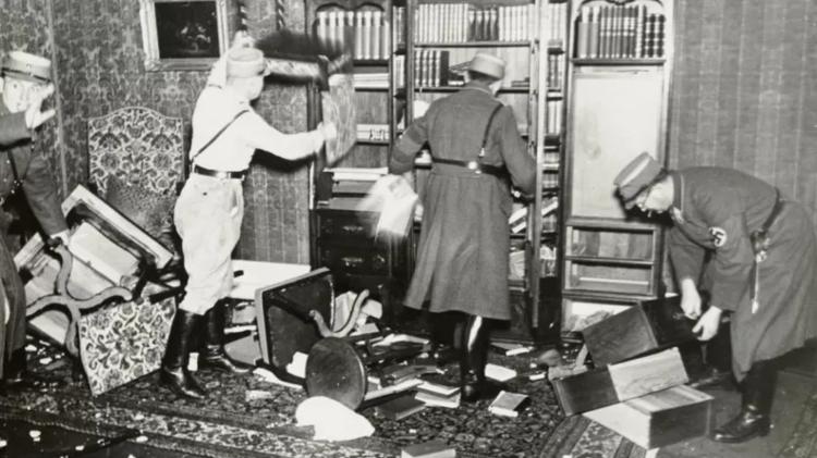 Nazi officers take books off the shelf - YAD VASHEM - YAD VASHEM