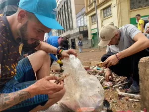 Vítimas das enchentes catam itens no lixo: 'Só tenho a roupa do corpo'