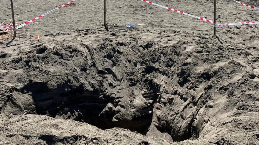 Buraco cavado por crianças em praia de Montalto di Castro, na região de Lácio, Itália