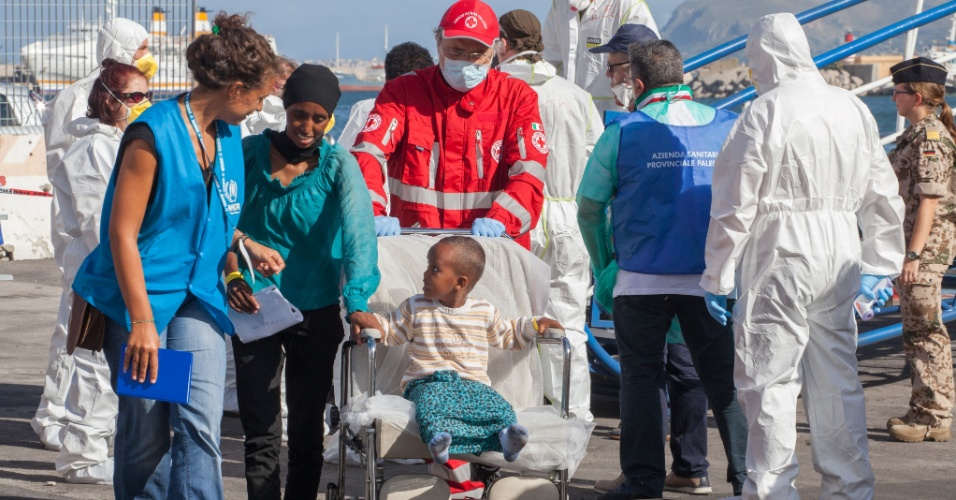 20.set.2015 - Refugiados chegam ao porto de Palermo, na Itália, no domingo (20), a bordo de uma fragata alemã. Estima-se que mais 767 refugiados chegaram pela embarcação, a maioria vindo do Sudão, Eritreia, Somália e Síria
