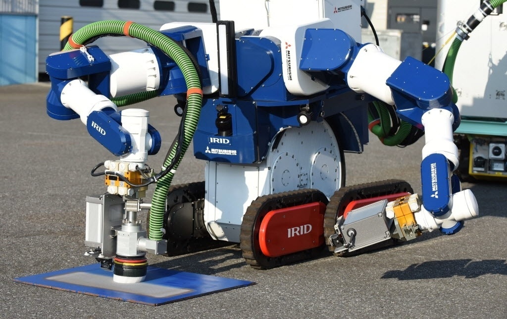 18.jan.2016 - A máquina, em forma de guindaste, possui dois braços robóticos capazes de pegar e cortar resíduos, e outro braço especialmente desenhado para agarrar as barras. A máquina está equipada com câmeras que permitem a observação dos trabalhos de retirada de múltiplos ângulos e controlar melhor as distâncias para evitar acidentes - Toru Yamanaka/AFP