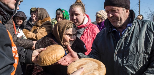 Voluntários do Centro de Ajuda Cristã da Igreja da Transfiguração em Maryinka distribuem pão para os moradores da cidade da Ucrânia - Brendan Hoffman/The New York Times