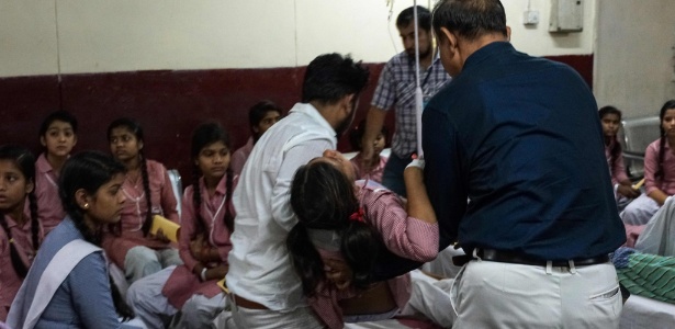 6.mai.2017 - Estudante indiana é atendida em hospital após vazamento de gás em um depósito de contêineres - AFP