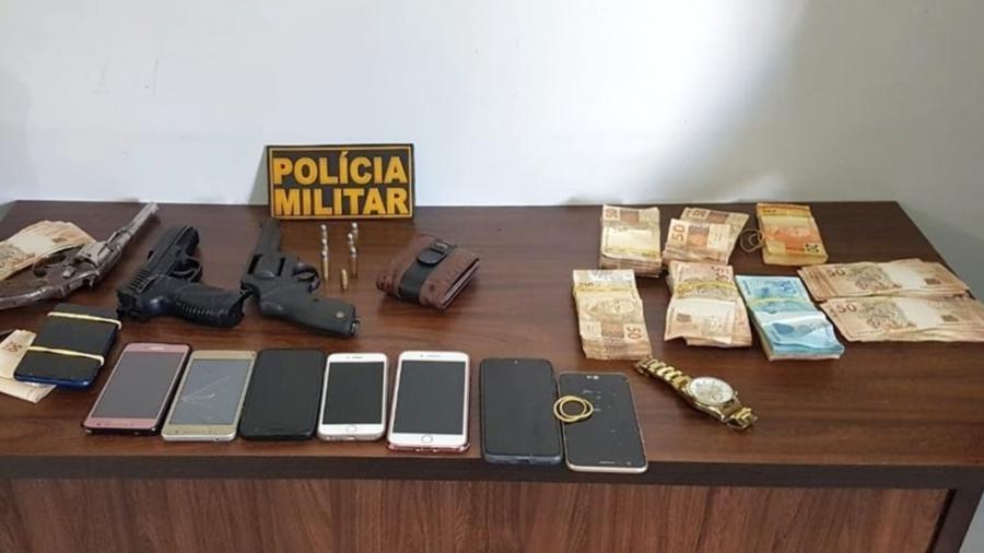 Os R$ 32 mil que haviam sido roubados, celulares de clientes, armas de fogo e um simulacro de pistola foram apreendidos com a dupla - Divulgação/Polícia Militar