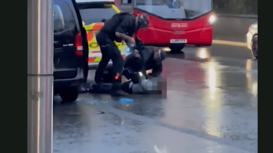 Vídeo divulgado pelo jornal britânico The Sun mostra suspeito que estaria baleado sendo rendido no chão por policiais. Um dos agentes aponta um rifle para o homem - Reprodução/The Sun