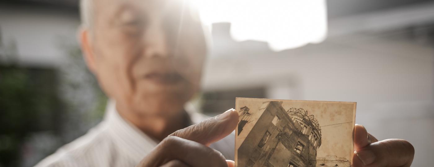 Kunihiko Bonkohara, sobrevivente de Hiroshima, mostra foto tirada por ele em 1960; a imagem é de um prédio destruído pela bomba atômica - Keiny Andrade/UOL