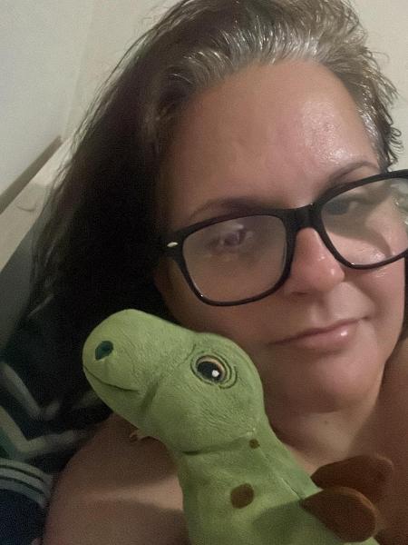 Karin está sempre com o dinossauro de brinquedo, comprado de presente ao seu filho