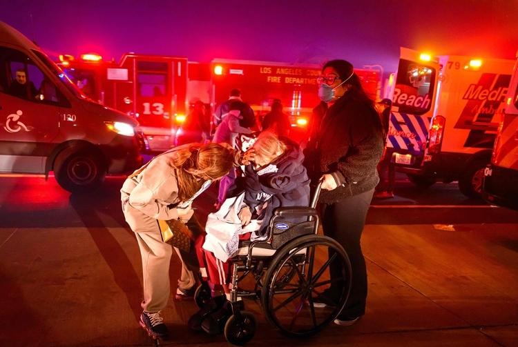 Ambulâncias dos bombeiros foram acionadas para prestar socorro a idosos no caminho de incêndio florestal em Pasadena; na imagem, Velma Wright, 102, é resgatada