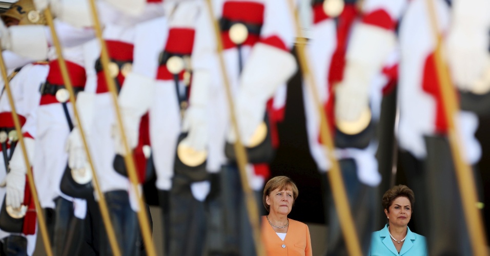 20.ago.2015 - Chanceler alemã Angela Merkel (e) ouve hino nacional brasileiro ao lado da presidente Dilma Rousseff (d) antes de reunião no Palácio do Planalto, em Brasília