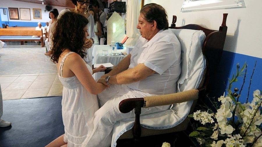 Em fotografia de 2012, mulher é atendida pelo médium João de Deus em um espaço público da Casa de Dom Inácio de Loyola - Getty Images