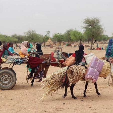 Refugiados sudaneses cruzam a fronteira entre o Sudão e o Chade para fugir do conflito entre Exército e paramilitares